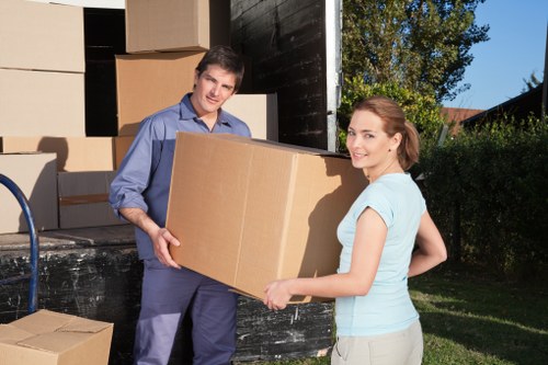 Movers carrying office furniture through a building entrance in Swiss Cottage